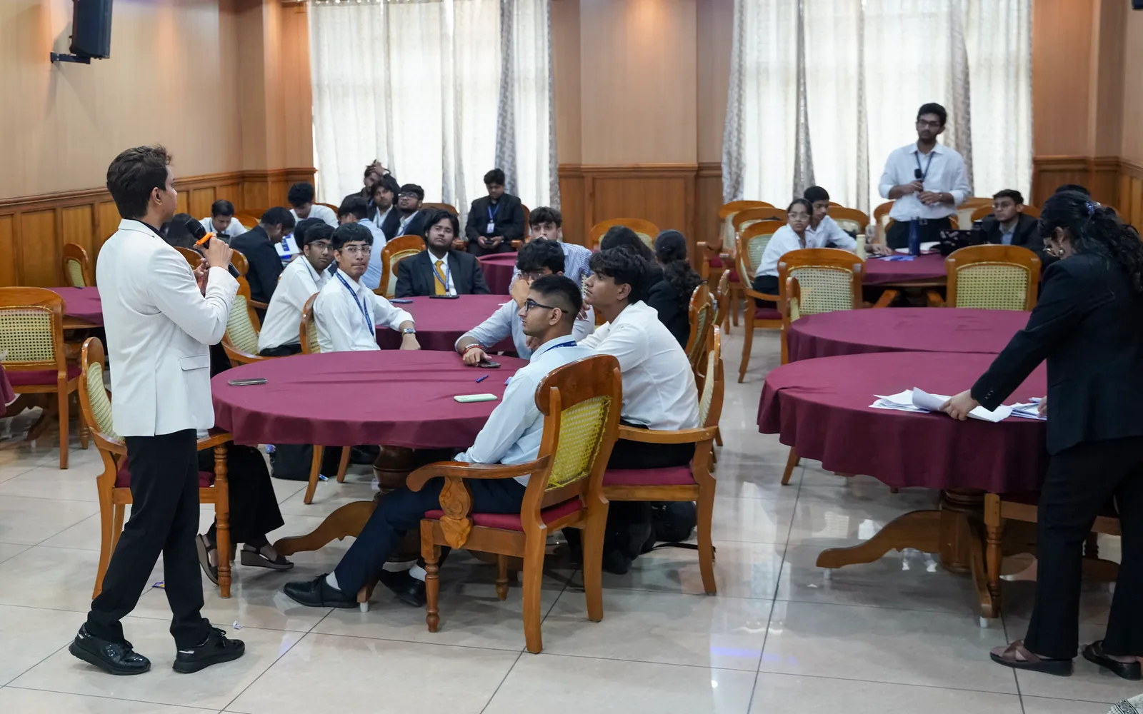 Students taking part in a workshop discussion around classroom tables.